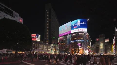 Pan video of crowd waiting and crossing at the Shibuya Intersection at night Stock Footage 127584871