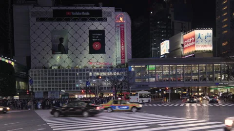 Pan video of crowd waiting and crossing at the Shibuya Intersection at night Video stock 127629353