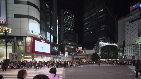 Pan video of crowd waiting and crossing at the Shibuya Intersection at night Video stock 127630278
