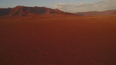 Pan view of cliffs line and desert dunes early in the morning Stock Footage 64939685
