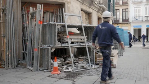 Pan view of a construction site in town with two workers. Stock Footage 122012147