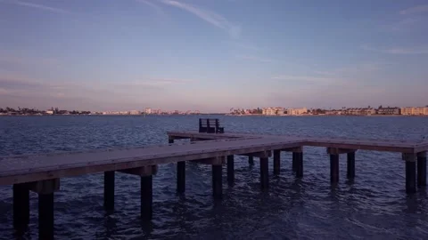 Pan View looking east over pier on edge of sea wall east of Pass A Grille Way Stock Footage 262371100