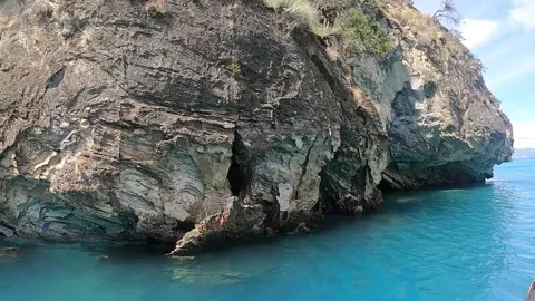 Pan view of Marble caves and cliffs from a boat on Lake General, turquoise water Vidéo 130608919