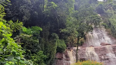 Pan view of natural jhari waterfall cascading down rocky cliffs surrounded .. Stock-Footage 346817047