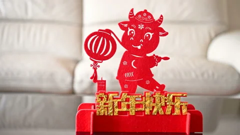 Pan view ox mascot with a lantern in front of a sofa as symbol of Chinese New Stock Footage 147925496