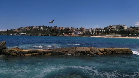 Pan view of waves hitting clips, at Coogee beach, on a sunny summer day, in S Stock Footage 86041990