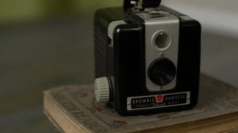 Pan from Vintage Photographs to Brownie Hawkeye Camera on Books Stock Footage