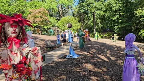 Pan-Visitors checking out Halloween scarecrows Stock Footage 287804500