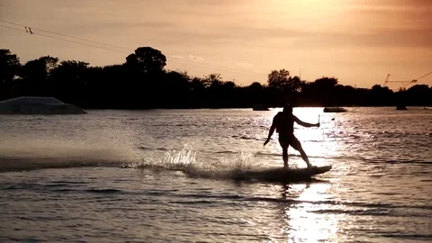 Pan of Wake Boarder Doing Half-Somersault at Sunset Stock Footage 76768367