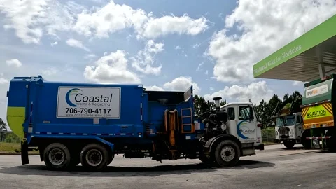 Pan of Waste management trash trucks filling up at a Natural Gas Stock Footage 180133617