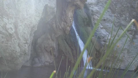 Pan of a Waterfall Through the Grass with Sunflares Stock Footage 217493594