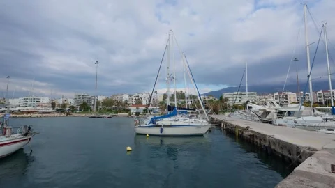 Pan wide angle of sailboat anchored in calm marina waters daytime Stock Footage 337459353