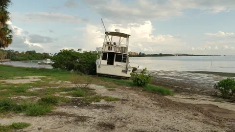 Pan Wide view out towards washed up on shore tall large blue and white Derelict Stock Footage 284732847