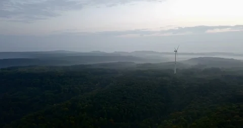 Pan on a wind power park on top of a forested hill the early morning in Germa Stock Footage 119819230