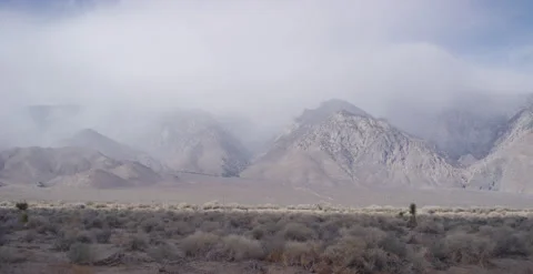 Pan on windy snow storm over Sierra Nevada rocky mountains. Vidéo 219307675