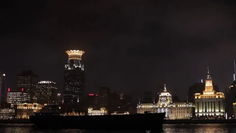 PAN WS Container ship moving along Huangpu River and The Bund skyline at night / Stock Footage 69946881