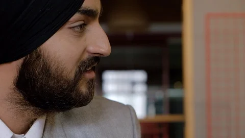 Pan from a young Sikh man having a serious closeup face to face discussion with  Stock Footage 102548118