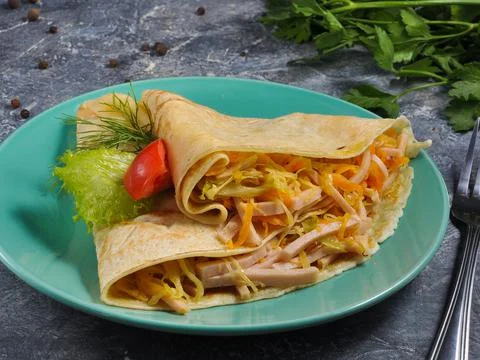 Pancake with cabbage and ham on a gray background Stock Photos
