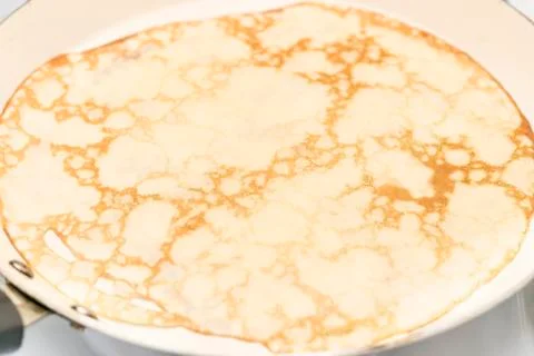 Pancake on a ceramic pan Stock Photos