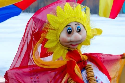 Pancake doll in bright multi-colored dress with bunch of bagels Stock-Fotos