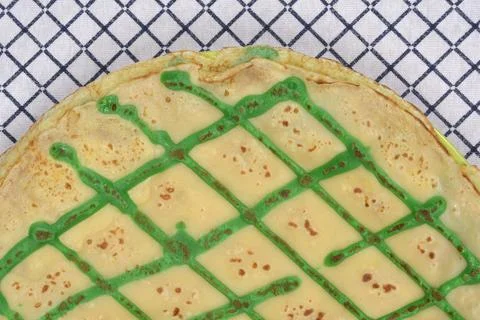 Pancake with green grid pattern on a checkered tablecloth Stock Photos