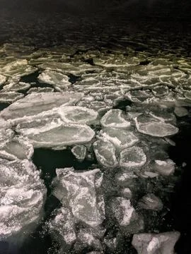 Pancake Ice Formations Floating on Dark Water at Night in Winter Stock Photos