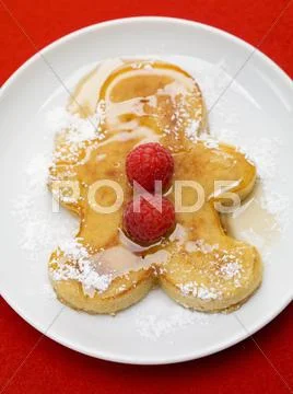 Pancake man with raspberries, icing sugar and maple syrup Stock Photos