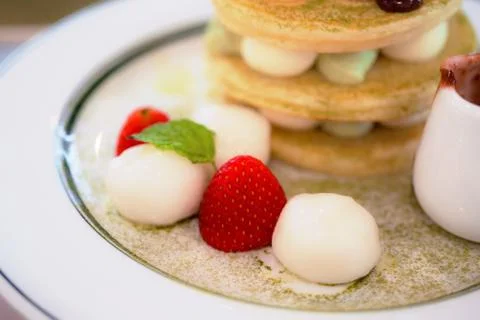 Pancake stack with green tea, syrup ,and strawberry isolated on white backgro Stock Photos