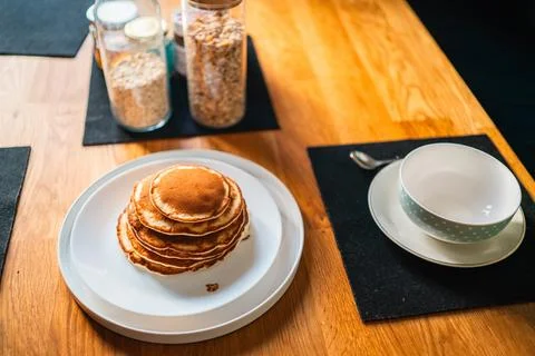 Pancake Stack on a Plate for Breakfast Near a Cereal Bowl Stock Photos