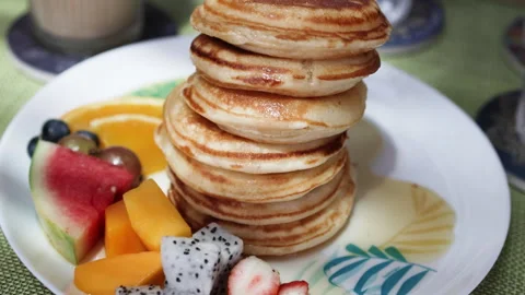 Pancake stack topped with vibrant fruits for delightful breakfast experience. Stock Footage 288063614