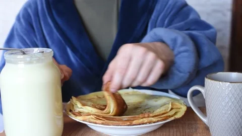 Pancake week, man eats pancakes with condensed milk.Sweet breakfast, still life Stock Footage 221360041