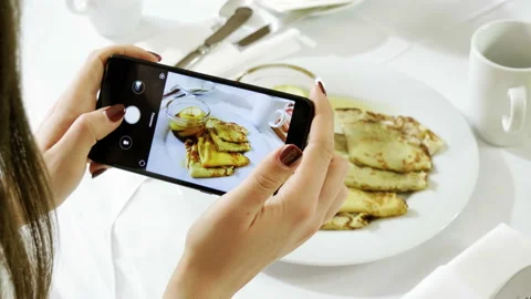 Pancakes with apple jam. Hands taking photo of breakfast food by smartphone. 4K Stock Footage 107935528