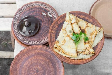 Pancakes on ceramic platter. Table setting in national traditions with french Stock Photos