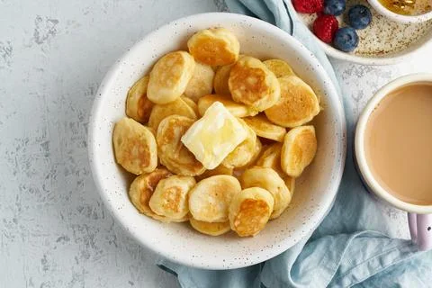 Pancakes cereal, tiny thin funny crumpet, children's food. Breakfast with drink Foto stock