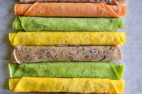 Pancakes of different color. Spinach, beetroot powder, blueberry and turmeric Stock Photos