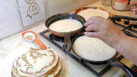 Pancakes fried in three pans at the same time Stock Footage 123588692
