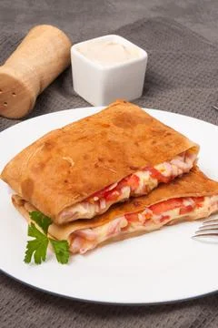 Pancakes with ham, cheese and tomatoes on a white plate. vertical frame Stock Photos