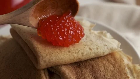Pancakes or blini with red caviar. Hands pick red caviar in a spoon. Pancakes Video stock 264187128