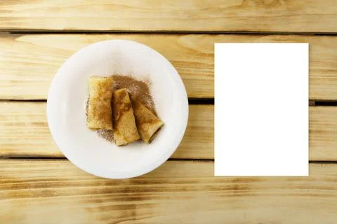 Pancakes on a plate, and a white sheet on a wooden background. Stock Photos