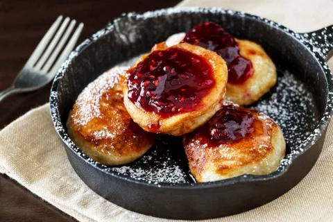 Pancakes with Raspberry jam in cast-iron frying pan. Stock Photos