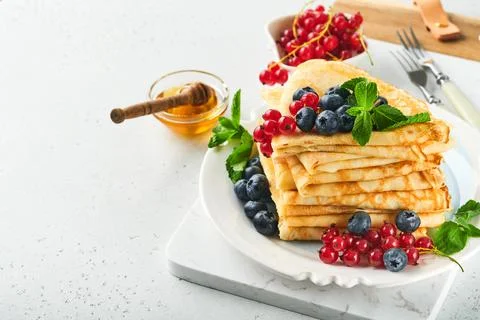Pancakes. Stack of crepes or thin pancakes with berries, blueberries, red cur Stockfoto's