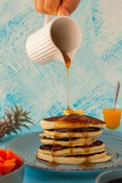 Pancakes stack pouring marple syrup. Little jug. Breakfast. Jem, Papaya. side Stock Photos