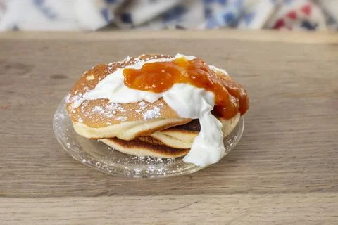 Pancakes stack with powdered sugar, greek yogurt and peach jam on wooden ta.. Stock Photos