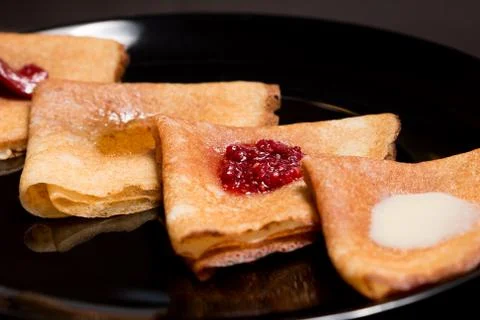 Pancakes with strawberry jam, raspberry jam , sour cream and honey Stock Photos