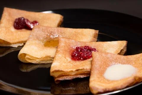 Pancakes with strawberry jam, raspberry jam , sour cream and honey Stock Photos