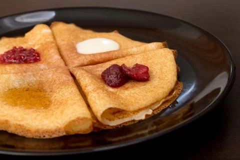 Pancakes with strawberry jam, raspberry jam , sour cream and honey Stock Photos