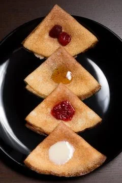 Pancakes with strawberry jam, raspberry jam , sour cream and honey Stock Photos
