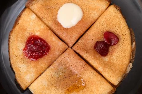 Pancakes with strawberry jam, raspberry jam , sour cream and honey Stock Photos