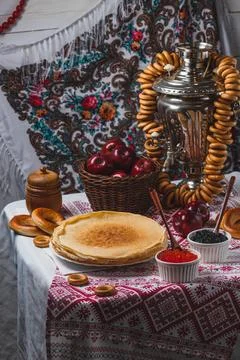 Pancakes on the table with traditional patterns, next to the samovar, apple.. 스톡 사진
