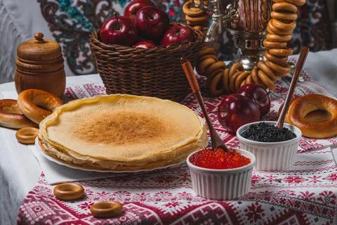Pancakes on the table with traditional patterns, next to the samovar, apple.. 스톡 사진